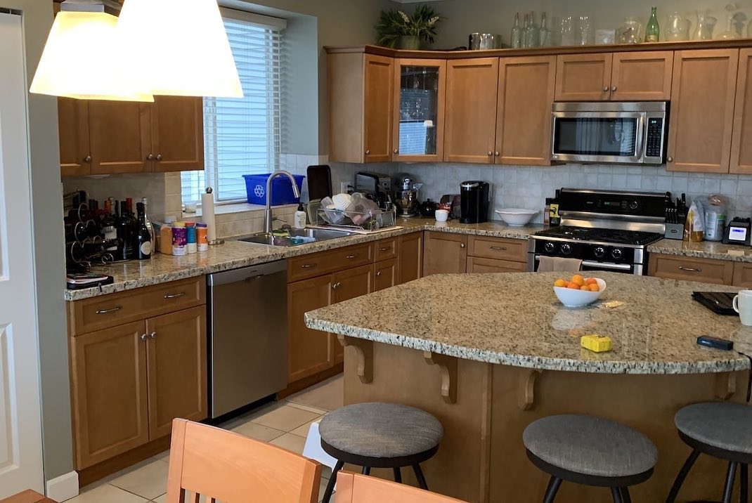 White kitchen before renovation with clutter and older finishes