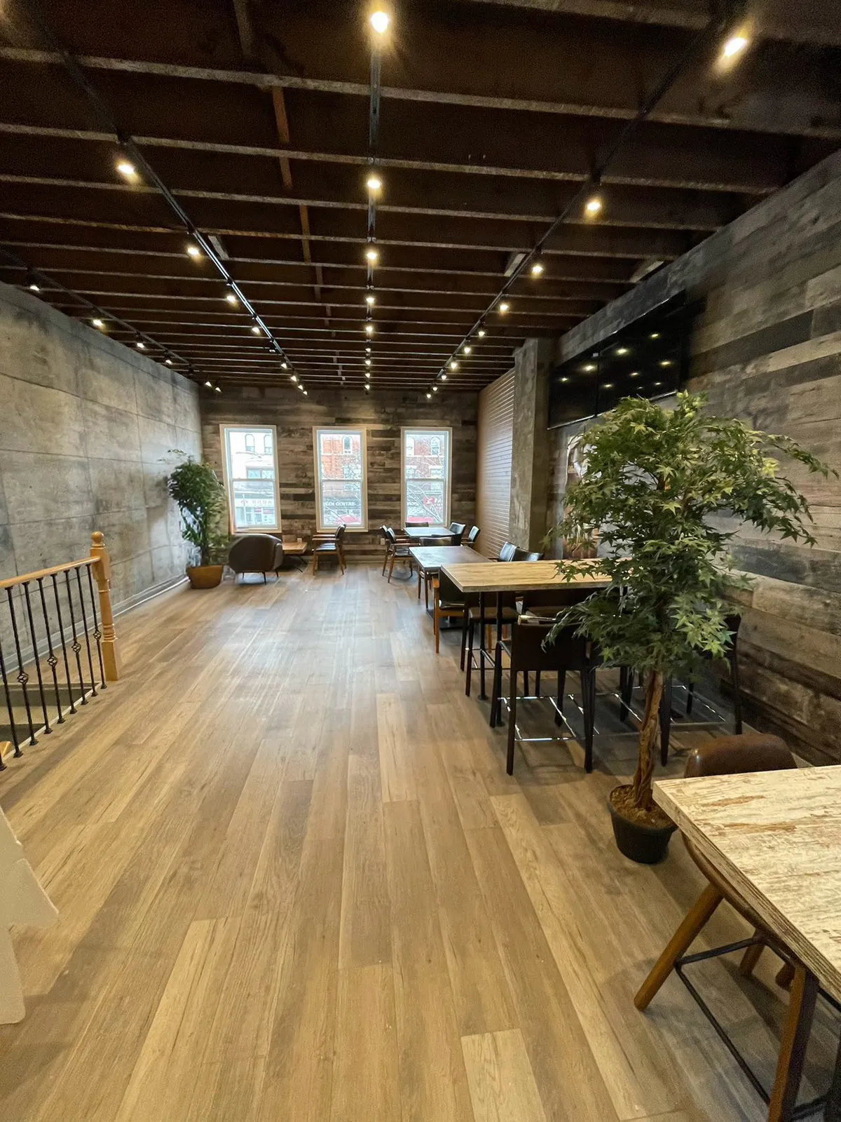 Completed restaurant dining area with wood-look flooring and track lighting