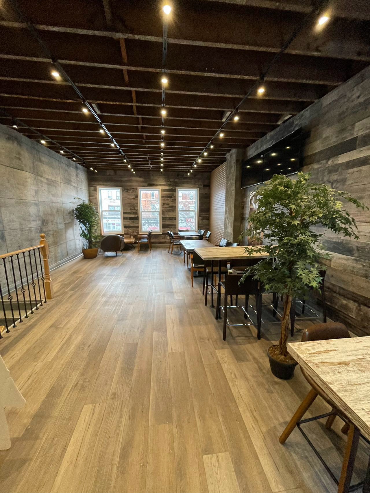 Finished restaurant dining area with wood-look flooring and track lighting