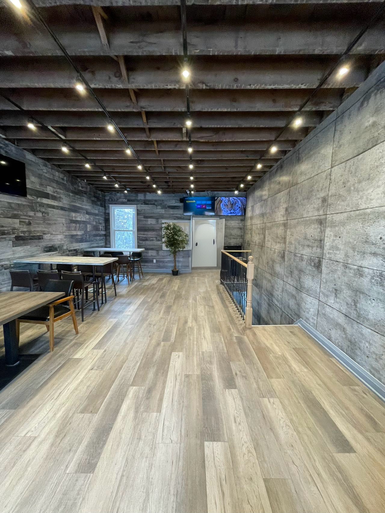 Finished restaurant dining area with gray wall panels and warm flooring